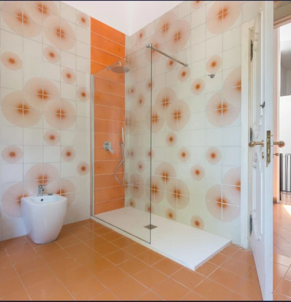 Bagno con doccia walk-in e decori arancio