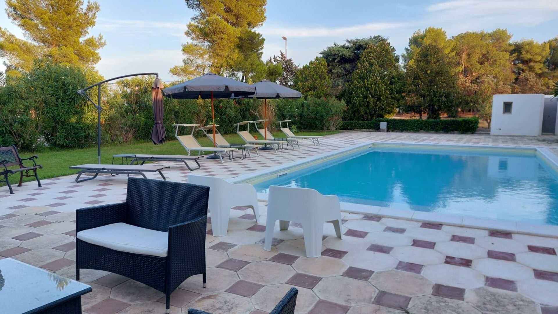 Piscina privata al tramonto tra ulivi e pini